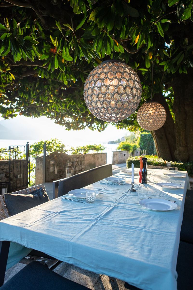 Table laid under the magnolia with lanterns