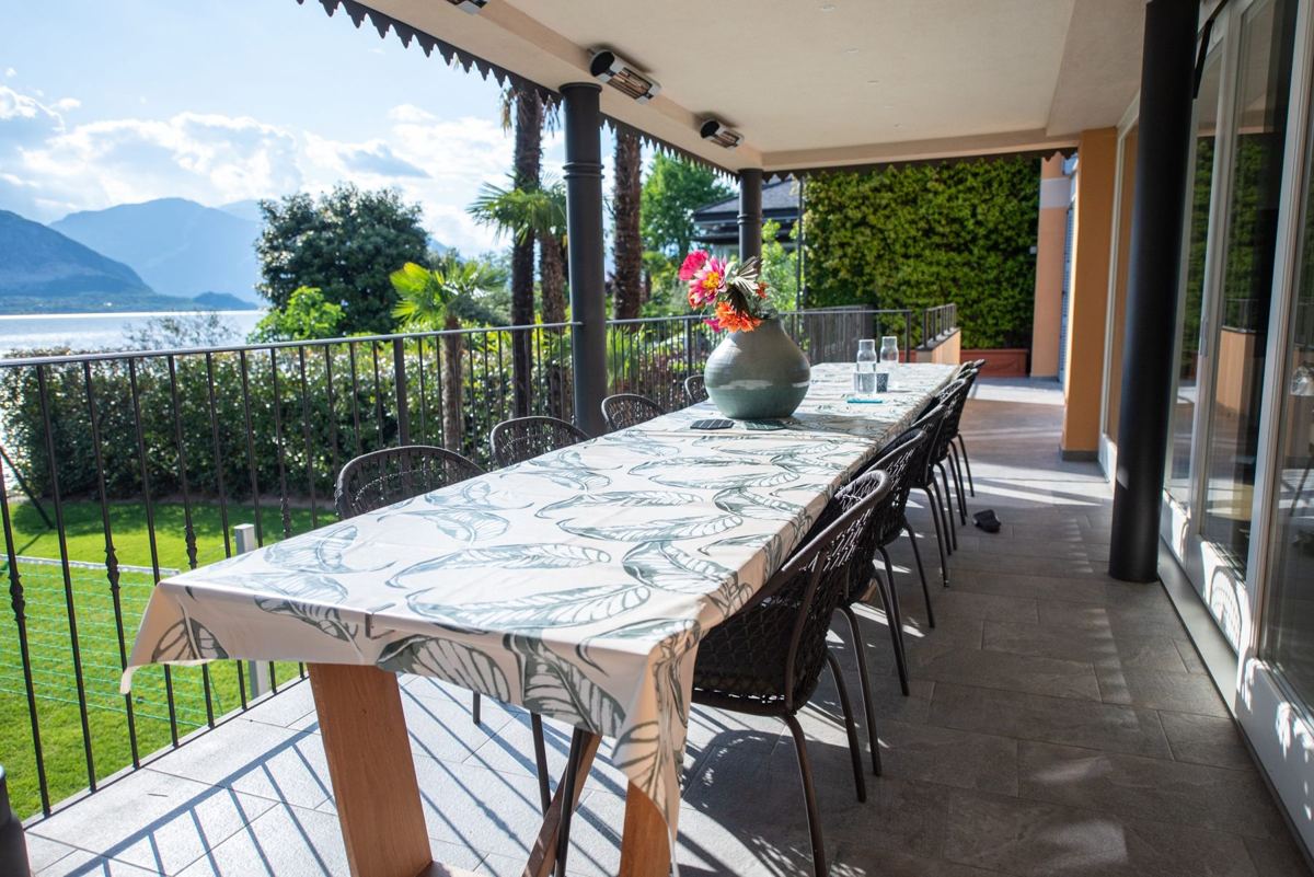 Long table laid on the covered terrace with lake view